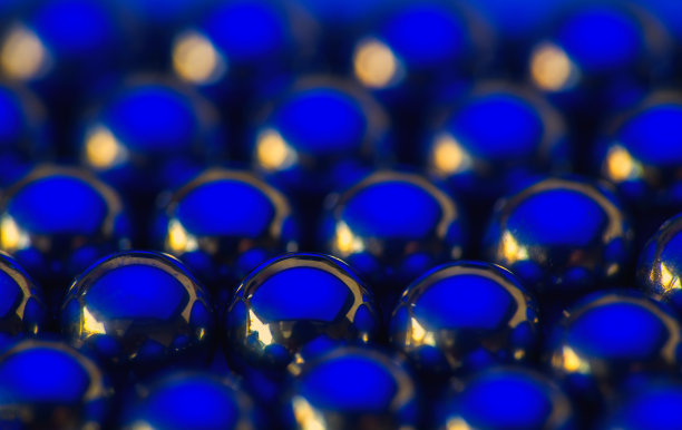 金属小球闪烁着蓝色和金色的光。微距照片，抽象背景图片下载