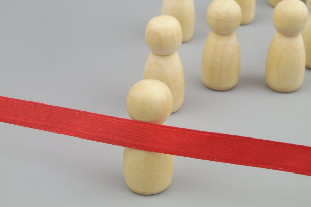木制人物的竞争对手和红色的终点线丝带在灰色的背景。图片下载
