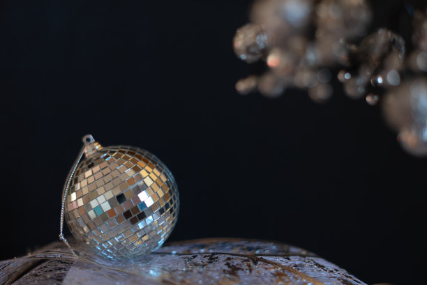 银色迪斯科镜球圣诞小玩意与选择性聚焦对黑色背景。圣诞节或冬季节日的庆祝概念。新年贺卡与复制空间的文字图片下载