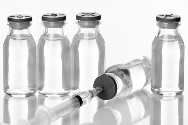 带针头的注射器从实验室的药瓶中吸入液体疫苗-健康、美丽和医学概念-白色背景隔离图片下载