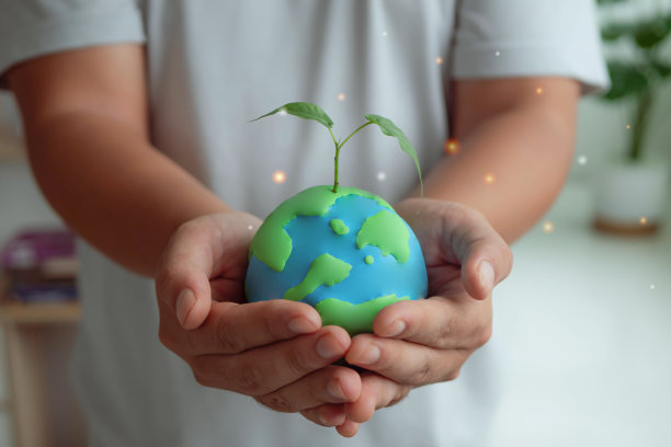 双手捧着绿色的地球仪，生长着树木。植树节。环保，拯救清洁地球，生态理念。地球日旗帜与复制空间图片下载