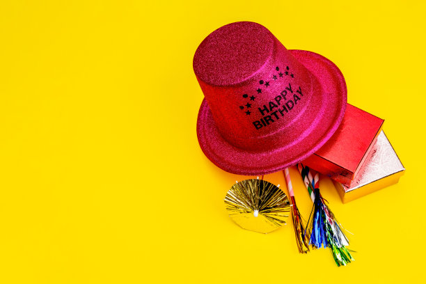 生日晚会的背景。邀请函，派对用品，生日哨子，派对眼镜和帽子，礼品盒，旗帜和餐巾。图片下载