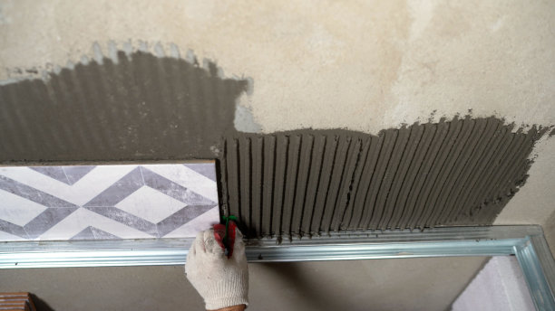 铺设瓷砖。时髦时髦的白色瓷砖。主人把浴室的瓷砖粘在一起。图片下载