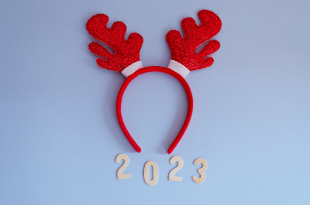 数字2023的俯视图。红色卡通鹿角特写。蓝色背景。新年，庆祝圣诞图片下载