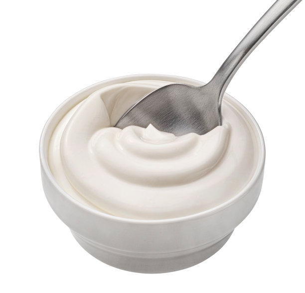 一碗酸奶油在勺子孤立的白色背景，俯视图图片下载
