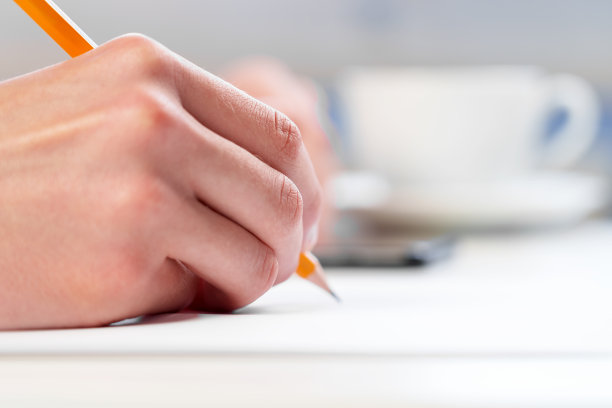 一个用手机和铅笔学习的年轻学生图片下载