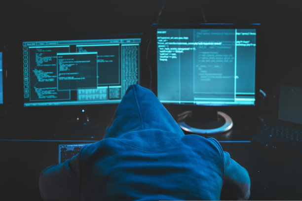 过度劳累的疲惫黑客。戴着兜帽的黑客在他的电脑前睡觉，屏幕上显示恶意代码软件，正在入侵数据中心。下载图片图片下载