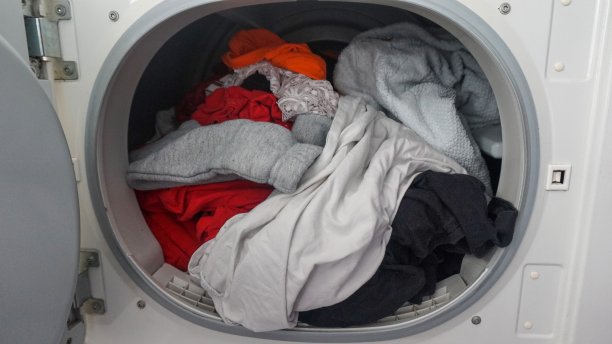 在开着门的洗衣机里洗衣服图片下载