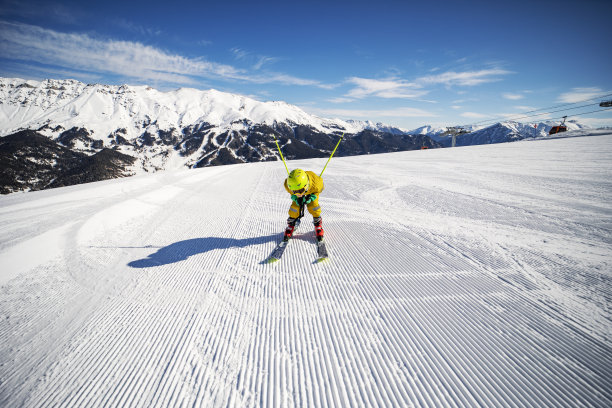 男孩在滑雪胜地的山上滑雪图片下载