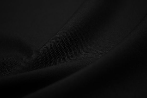 暗黑色面料的质感特写。低调照片。丛线程。服装行业。抽象的背景。黑色纺织波。黑布背景图片下载