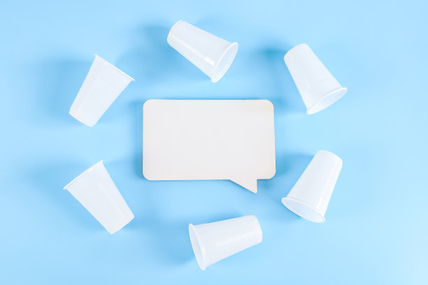 空的标注和塑料杯在蓝色的禁酒标志下围成一圈。图片下载