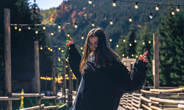 一位年轻女子正以群山为背景跳舞。图片下载