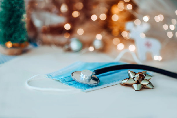 听诊器和面具映衬着闪烁的金色花环。新年和圣诞节的健康理念。副本的空间。图片下载