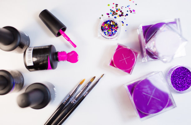 美容工作室。白色背景的修甲材料。刷子，亮片，粉色指甲油。图片下载