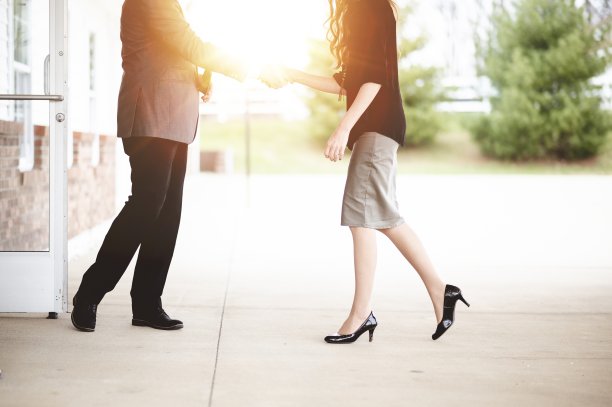 以明亮的阳光为背景，男男女女握手致意图片下载