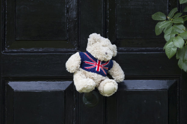 英国房子的黑色前门上有英国国旗的泰迪熊图片下载