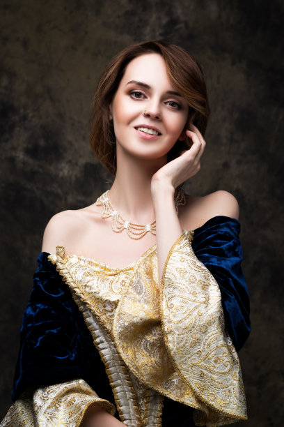 快乐的美丽女人在文艺复兴时期的皇家服装在抽象的黑色背景图片下载