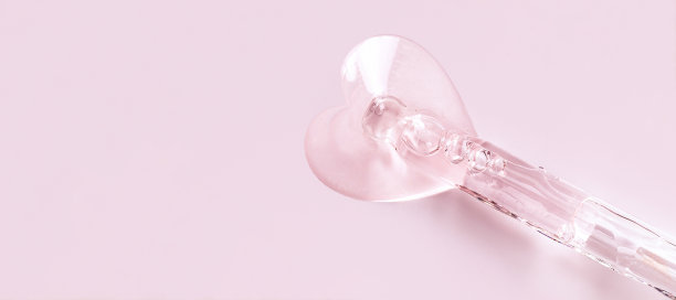 移液管上有粉色背景上心形的血清滴图片下载