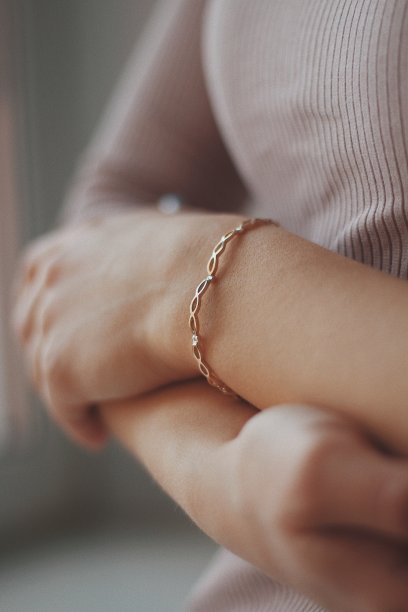 一个戴着金手镯的女性的垂直特写镜头图片下载