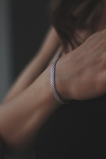 一个戴着漂亮银手镯的年轻女性的垂直镜头图片下载