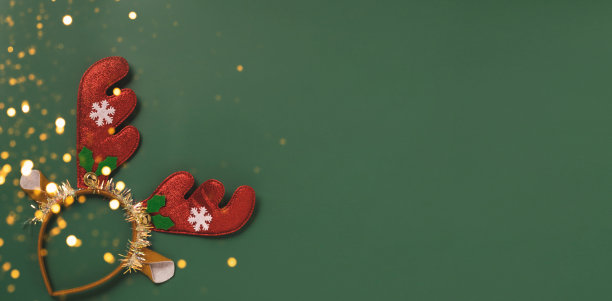 圣诞新年喜庆布置的饰品，闪亮的牛角花环，绿色背景的玩具图片下载