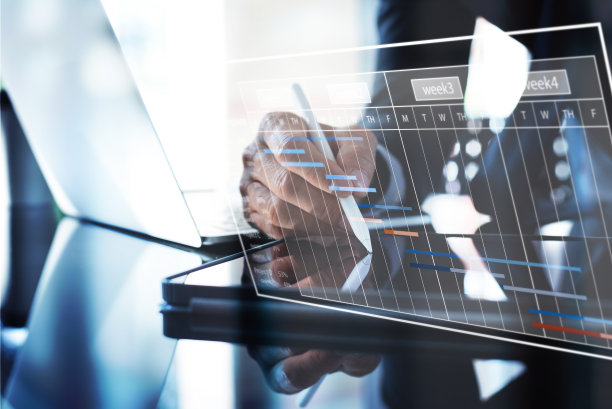 项目经理更新任务和里程碑进度计划的数字平板电脑与虚拟屏幕上的甘特图调度界面图片下载