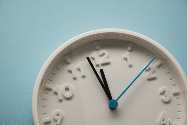 蓝色背景下12点的挂钟图片下载