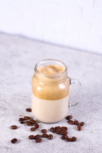 垂直拍摄的焦糖冰沙包围着桌上的咖啡豆图片下载