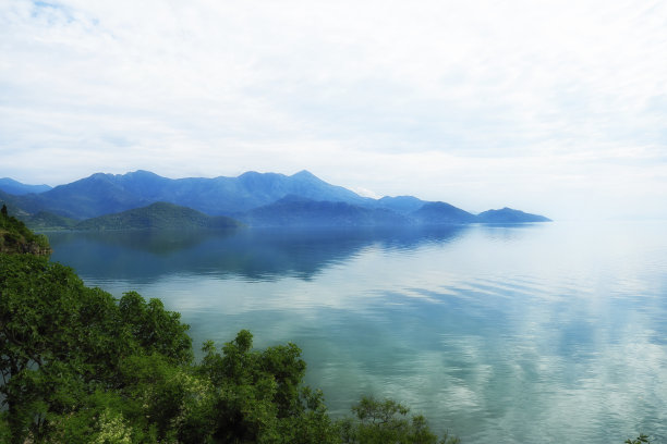 宁静的蓝色风景，有雾湖和山的背影图片下载