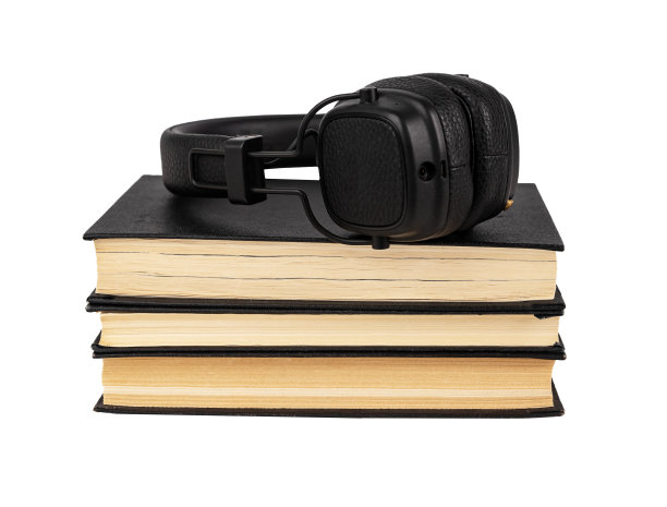 书本上的耳机堆叠在白色背景上。听有声读物的概念。音频讲故事。教育、文学研究观念图片下载