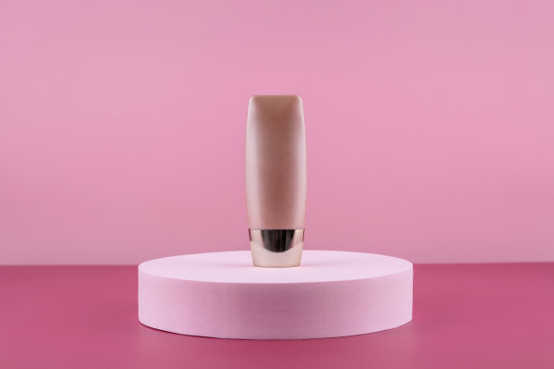 米色遮瑕底色化妆品产品在粉色背景上模拟。化妆品液体基础奶油瓶模型在圆讲台基座。护肤美容底漆，bb cc校正液图片下载