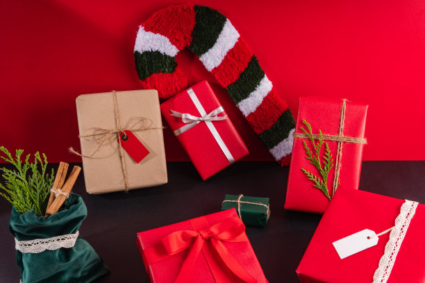 静物画的圣诞礼物用红色、绿色和牛皮纸包装，上面有空白标签和一簇甘蔗糖图片下载