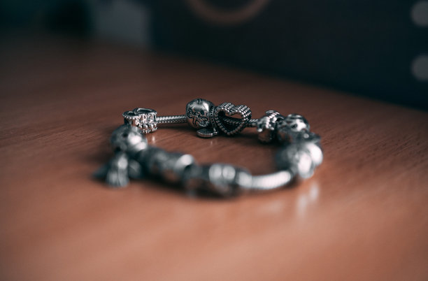 金属手镯在木质表面上的选择性聚焦镜头图片下载