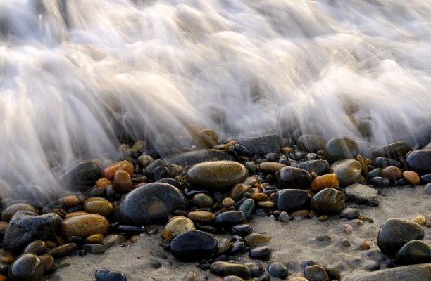 近距离拍摄的卵石覆盖的海洋泡沫图片下载