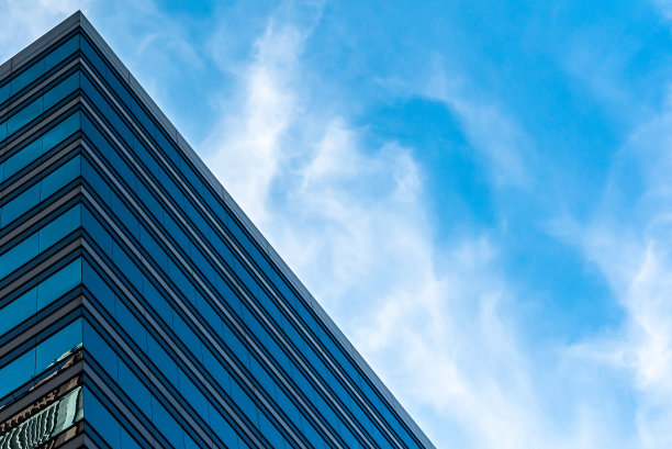 在多云的蓝天下，低矮的玻璃建筑镜头图片下载