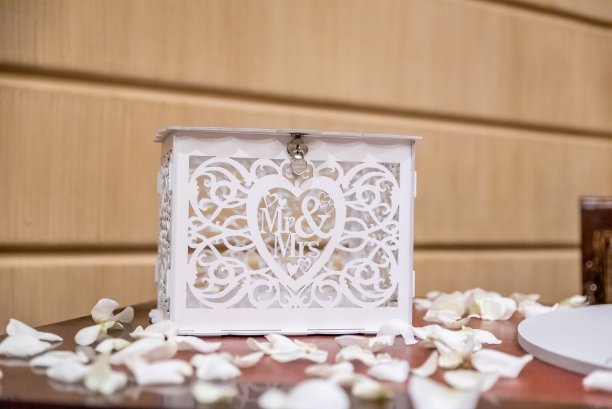 一个白色的盒子，桌子上有一个先生和夫人的标志，上面撒满了婚礼上的花瓣图片下载