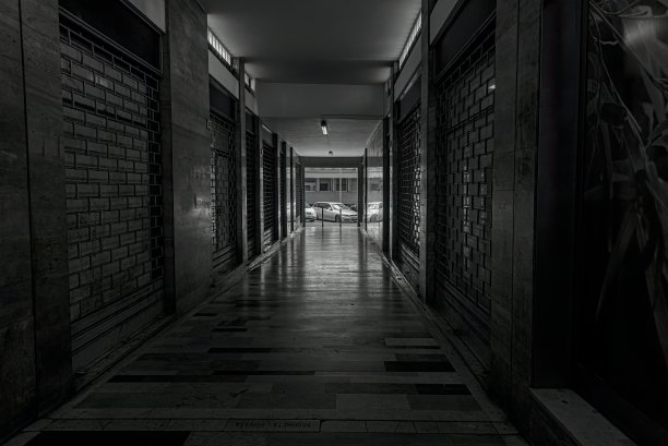 灰阶镜头下通往街道的空走廊图片下载