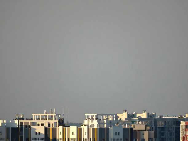 一个崭新的现代化住宅综合体，由几幢高层建筑组成，立面明亮，迎着天空。图片下载