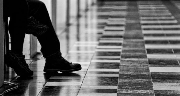 两对腿在瓷砖地板背景上的灰度照片图片下载