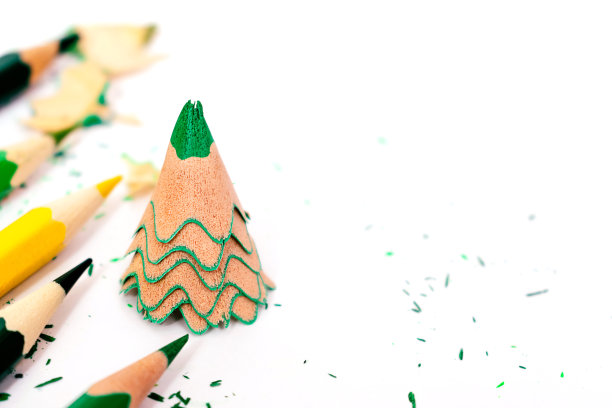 彩色铅笔和用绿色铅笔削成的创意圣诞树。圣诞节和新年的公寓铺在白色的背景上。图片下载