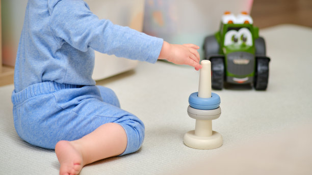 蹒跚学步的小男孩在家庭房间的地板上玩金字塔。在儿童房玩玩具的孩子。一岁零三个月的孩子图片下载