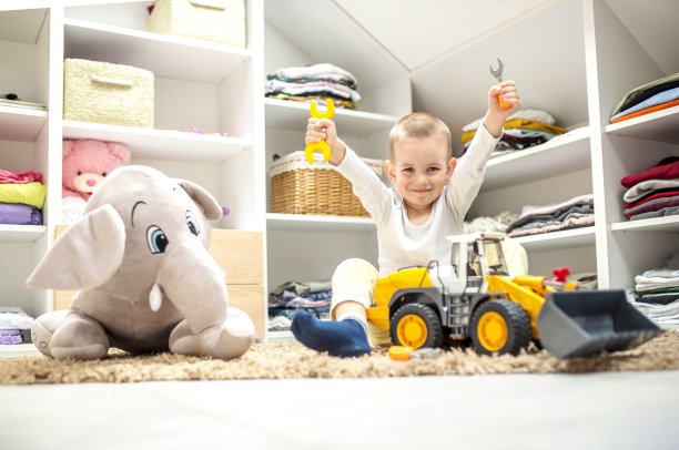 可爱的小男孩坐在游戏室的地板上玩玩具图片下载