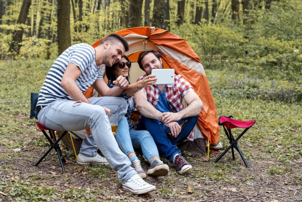 兴致勃勃的年轻朋友在野餐时拍照自拍照图片下载