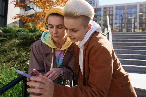 两个女人一起看手机上的照片图片下载