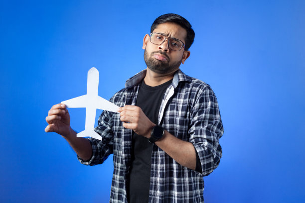 男子手持剪纸飞机。图片下载