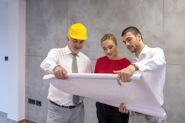 建筑师向一对年轻夫妇展示新公寓的平面图图片下载