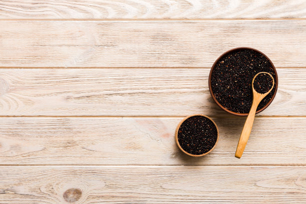 在碗和勺子里的藜麦种子在彩色背景上。健康的kinwa在小碗里。健康的超级食物图片下载