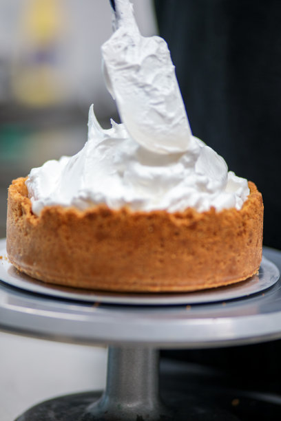 糕点师设计师用抹刀将青柠味蛋白酥皮填满图片下载