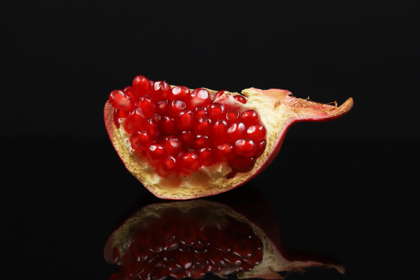 黑色背景上的红石榴。浅景深图片下载