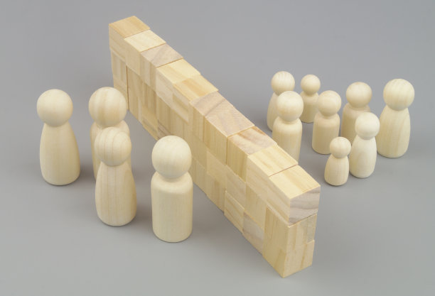 父母和孩子的木制人物被用木块做成的墙隔开。图片下载